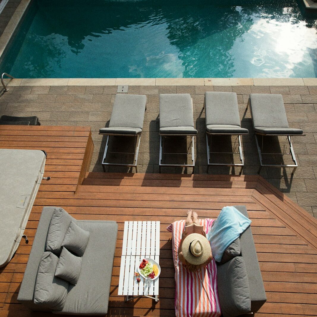 four gray loungers near pool